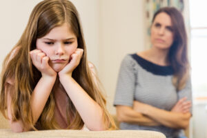 Daughter sitting upset with her mother in living room