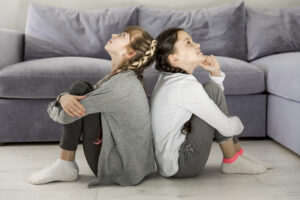 girls-sitting-back-back