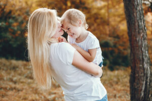 Mother with daughter playing in a summer park
