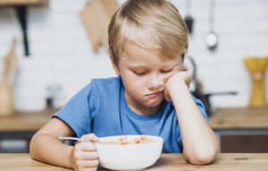 tired-boy-trying-eat-his-cereals