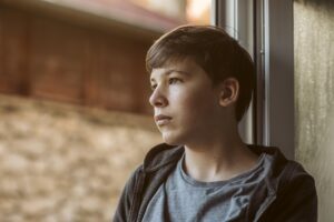 Kryzys tożsamości u dziecka – kiedy gubi się własne „Ja” i jak może pomóc mądry rodzic side-view-sad-boy-looking-outside