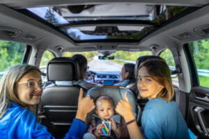 Thumbs up on the road. Kids cheering baby in car seat