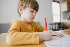 side-view-child-drawing-home
