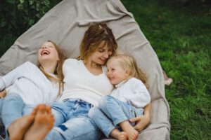 mother with children having fun in a hammock. Mom and kids in a