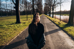 Gdy nastolatek nie chce rozmawiać... Portrait of a brunette girl having fun in a park in the rays of the bright sun.